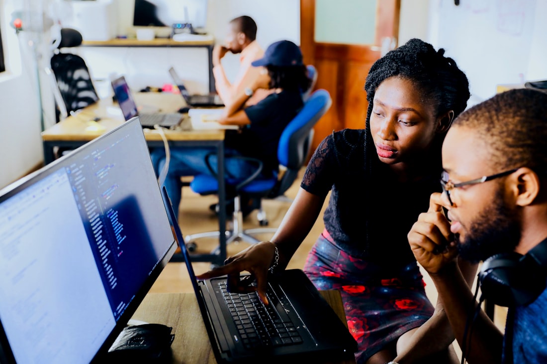Docentes colaborando frente a una laptop para crear su curso online